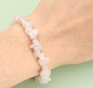 a hand wearing a lavender blush rose quartz bracelet